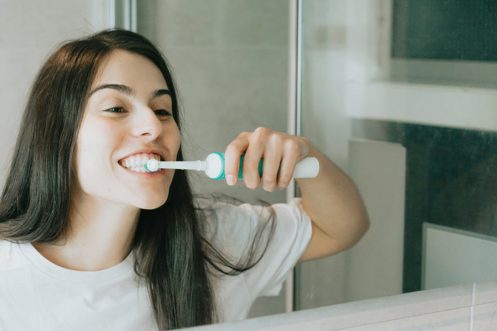 files/woman-brushes-with-an-electric-toothbrush-in-a-mirror.jpg